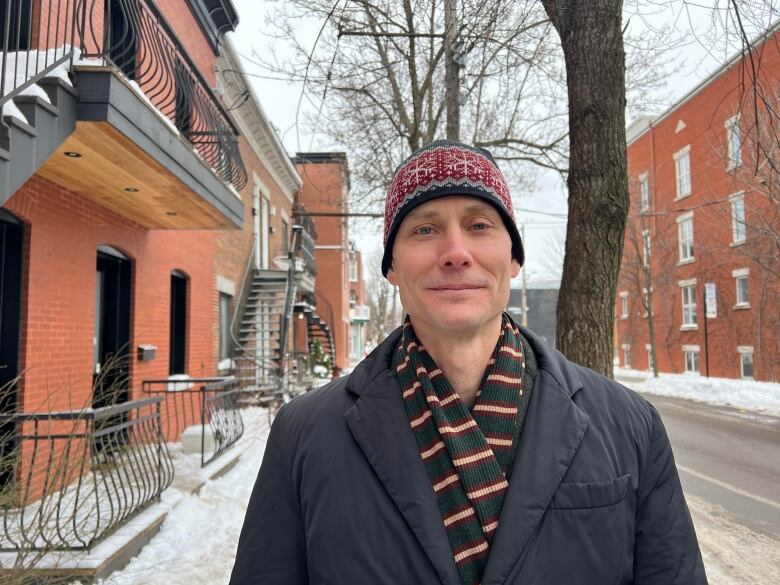 A man stands outside in the street.