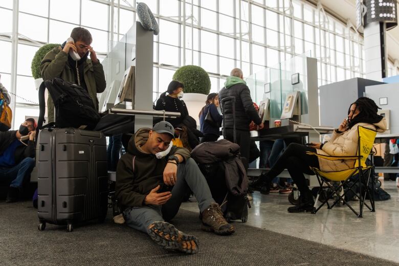 Travellers are seen waiting to speak to an agent at Toronto's Pearson Airport. 