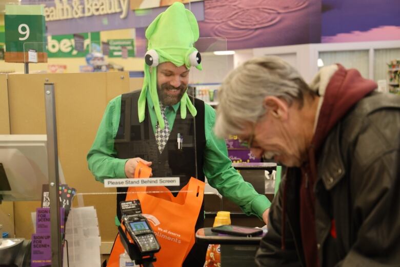 Jason Rutledge puts grocery items into a reusable bag at the slow check-out lane at the Belmont Sobeys in Edmonton.