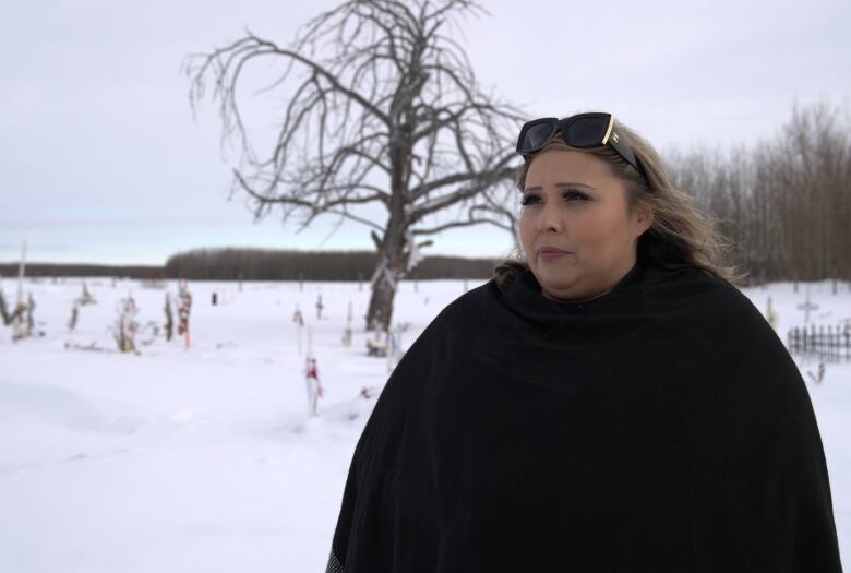 Leah Redcrow looks off-camera during an interview at the Sacred Heart cemetery grounds.