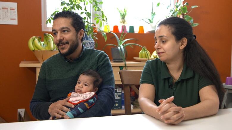 People sitting with a baby. 