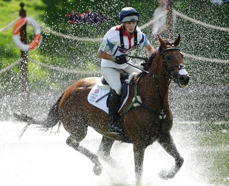 A person rides a horse in a cross country event.