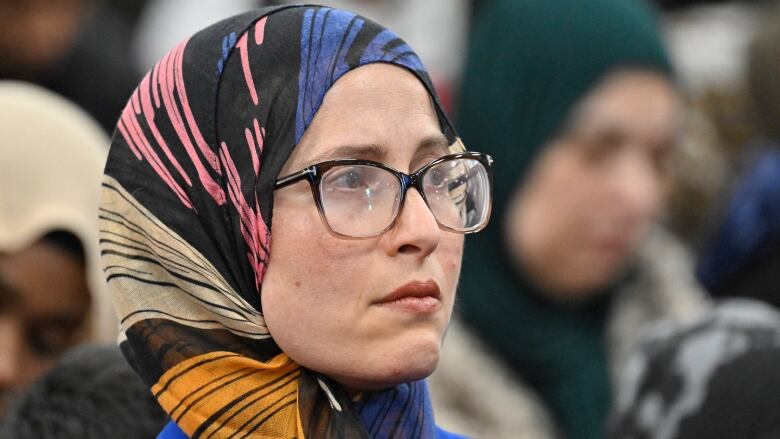 Headshot of a woman with glasses wearing a headscarf.