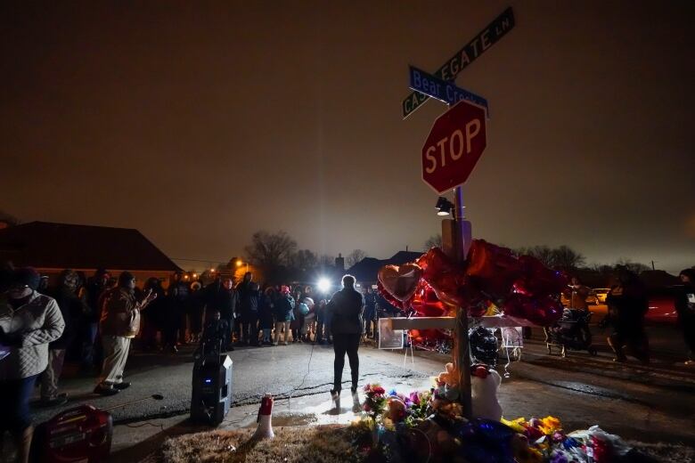 People father at a vigil held at a street intersection.