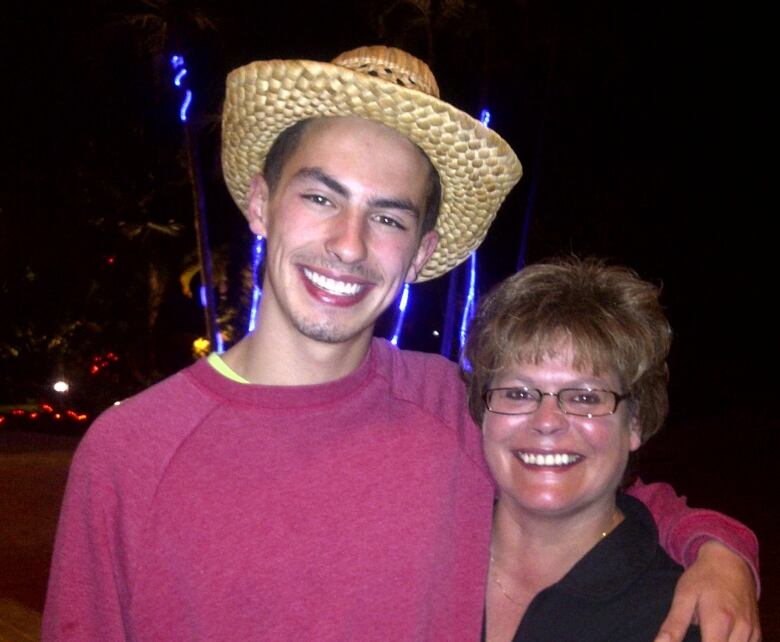 Tall young man in sombrero, smiling mother.