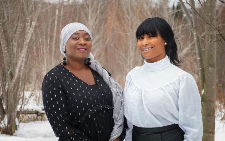 Two women pose outside in winter time.