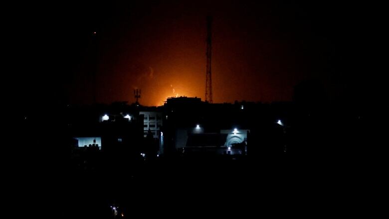 Smoke and flames are seen rising following Israeli airstrikes in Gaza City on Thursday.