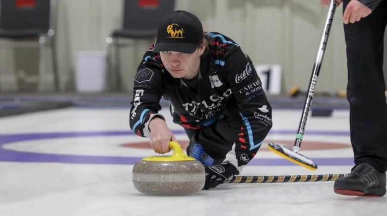 A curler slides out of the hack and delivers a rock.