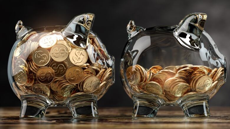 Two clear piggy banks facing right with gold coins that have the money sign $ on them. There is a black background.