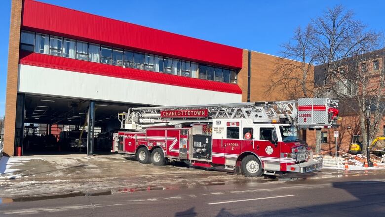 A ladder truck leaves the fire hall in city downtown