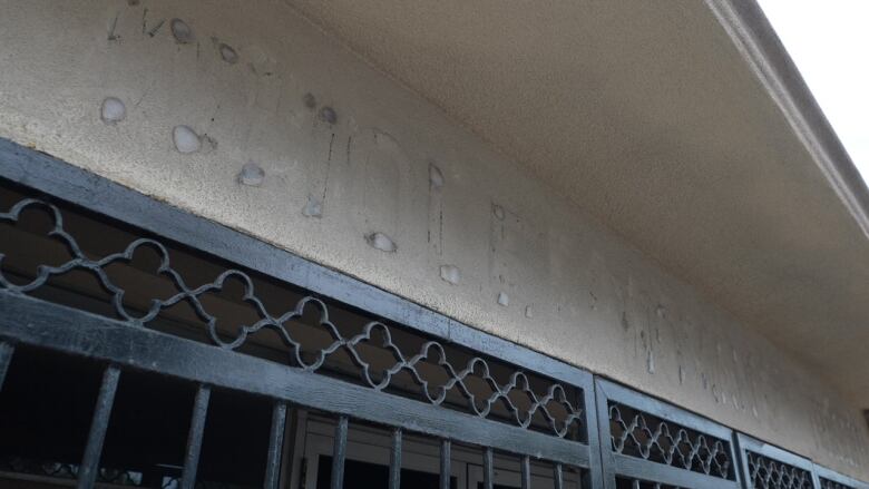 A nondescript low building, with stains outlining where the lettering 'Whole Woman's Health' has been removed from over the front door.