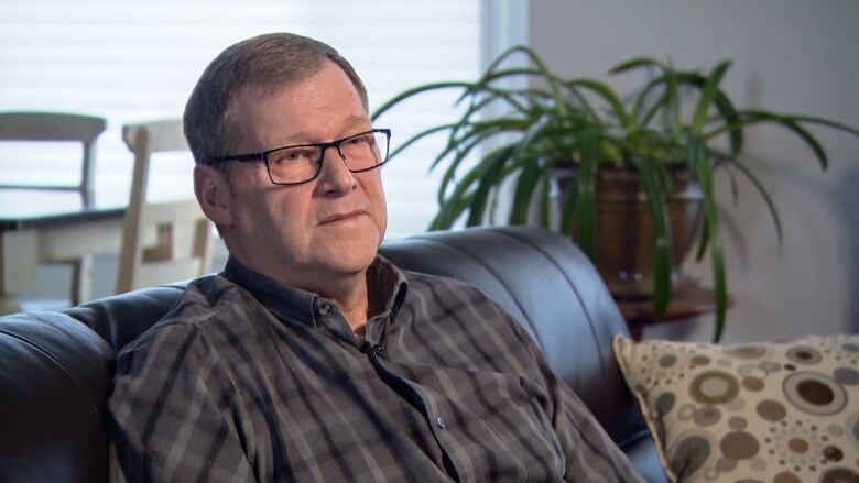 Brian Simpson sits on a couch during an interview with CBC News on February 2, 2023.