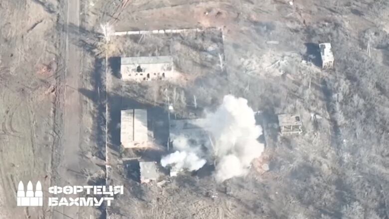 An aerial view of a smoking rural building.