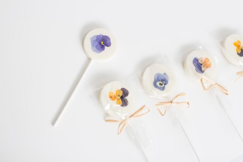 Edible flowers adorn pastry pops on sticks.