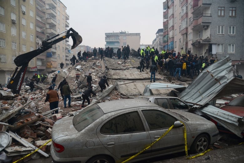 Rescuers and residents search for survivors at the site of a collapsed building.