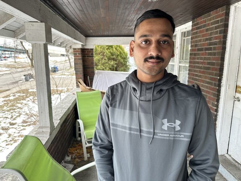 A man stands on a porch.