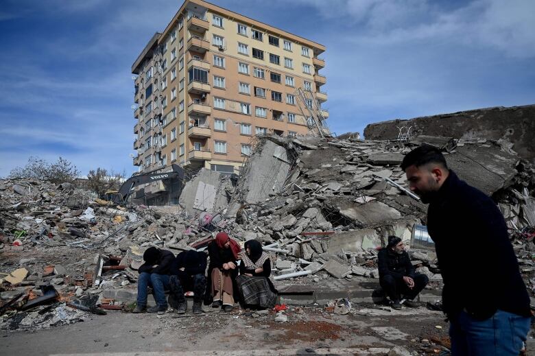 In broad daylight, families sit near building rubble in Kahramanmaras, Turkey, the quake's epicentre following Monday's earthquake.