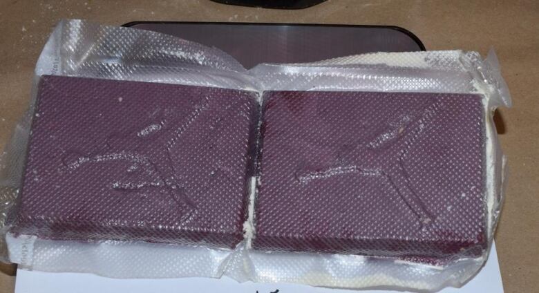 Two square purple-ish-brown blocks of pressed fentanyl.