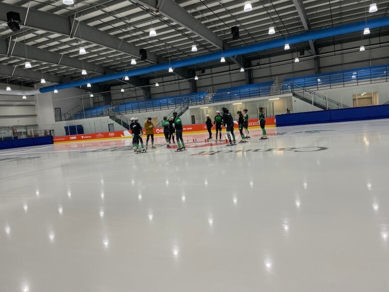 Short track speed skaters on the ice in a large arena. 