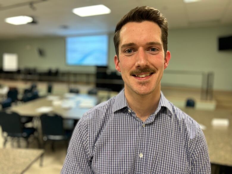 Shawn Martin, harm reduction coordinator with the Chief Public Health Office dressed in a checkered shirt at a public meeting on a supervised injection site.