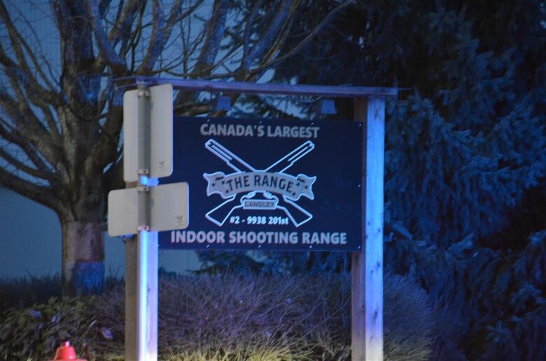 A sign for a Langley shooting range, featuring crossed revolvers and large words reading THE RANGE