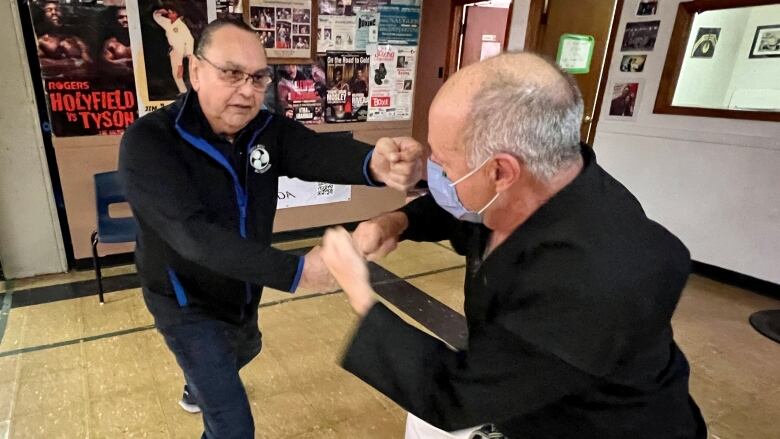 Two men spar with each other.