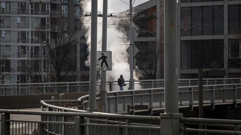 A pedestrian walks along the north end of the Granville Street bridge in Vancouver, B.C., on Feb. 8, 2023. The bridge's redesign will see the removal of traffic loops at the north end of the bridge. 