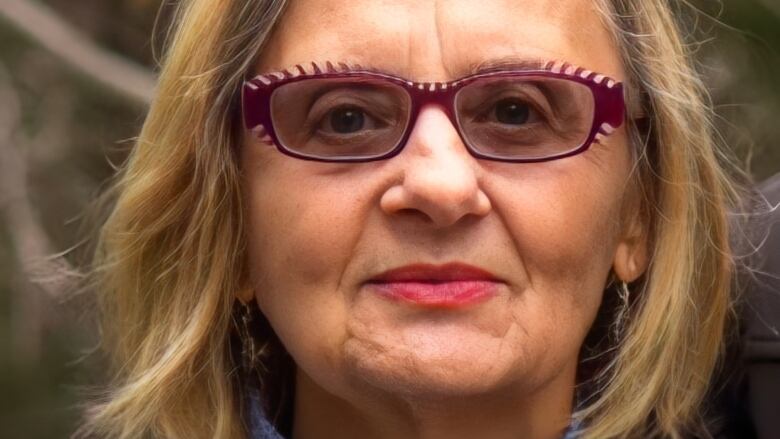 A close-up shot of a woman wearing glasses.