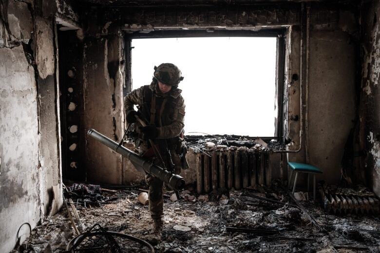 A soldier is shown inside a damaged room.