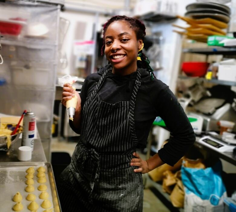 Rochelle Williams smiles to camera with a cake piping bag