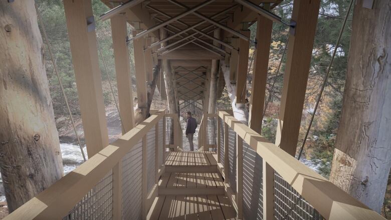 A man stands at the far end of a wooden, pedestrian foot bridge.