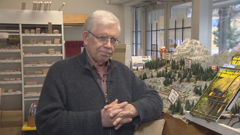 Hal Kinsey leans against a model train display.