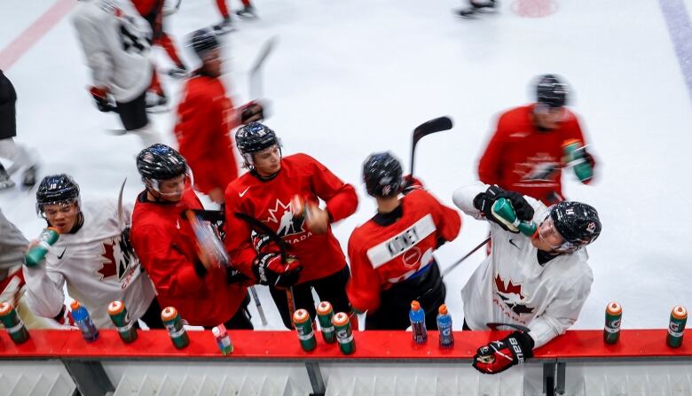 Hockey players take a water break during practice.