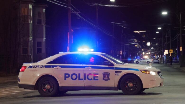 A Halifax police car is parked in the middle of the street and another police car can be seen in the distance also parked in the middle of the street.