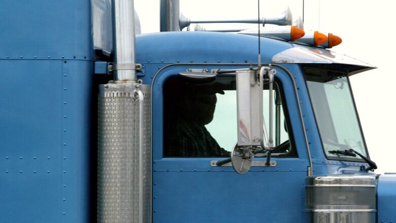 A driver sits inside a truck.