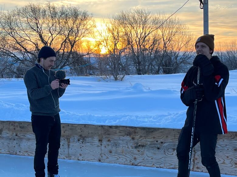 Filmmaker Randy Frykas, left, interviews outdoor rink owner Darryl Wiebe on his farm near MacGregor Manitoba.