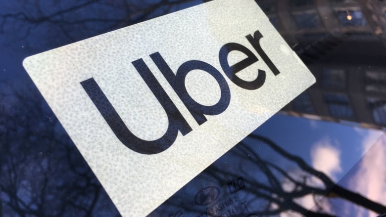 An Uber logo in the windshield of a car.