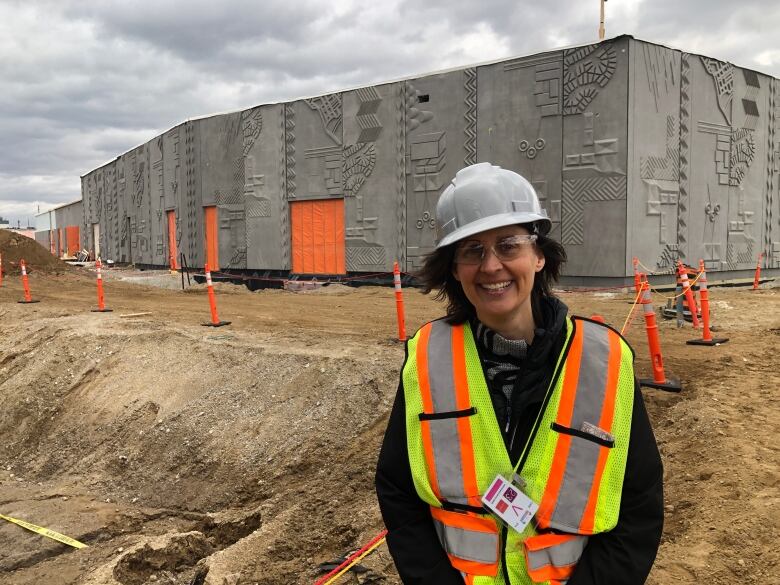 Artist Sara Graham stands by the artwork she commissioned on the facade of a building at the Gordie Howe International Bridge.