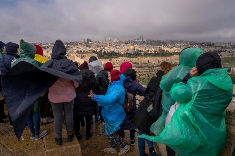 Tourists are seen at an observation point on the Mount of Olives, overlooking Jerusalem's Old City, earlier this month.