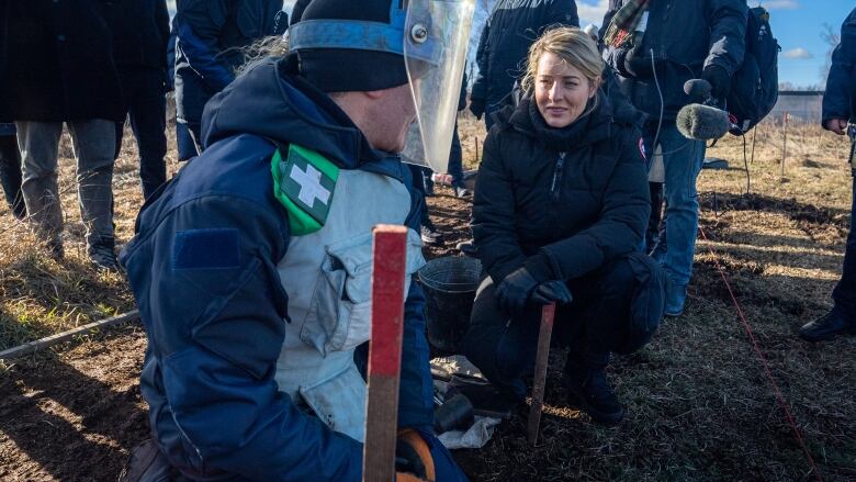 Foreign Affairs Minister Melanie Joly speaks with a volunteer at a de-mining training facility outside Kyiv on Feb. 15, 2023.