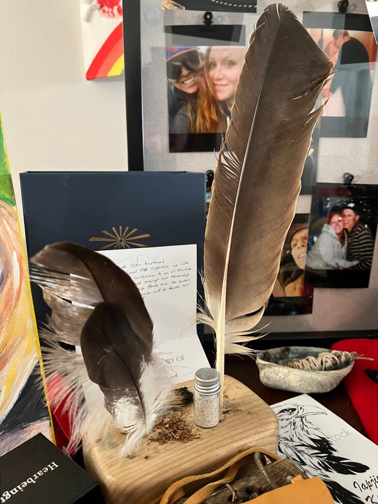 An eagle feather sits in on a wooden base on the kitchen table. 