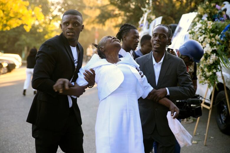 A relative of a slain police officer cries at the funeral for three officers killed in the line of duty in the Petion-Ville district of Port-au-Prince, Haiti on Jan. 31, 2023. The officers were killed in an ambush by gang members in the capital on Jan. 20.