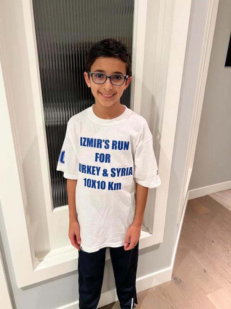 A young boy wearing a white t-shirt with the words 