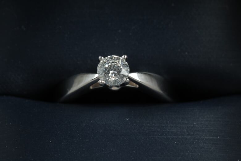 A close-up of a diamond set in a white gold ring.