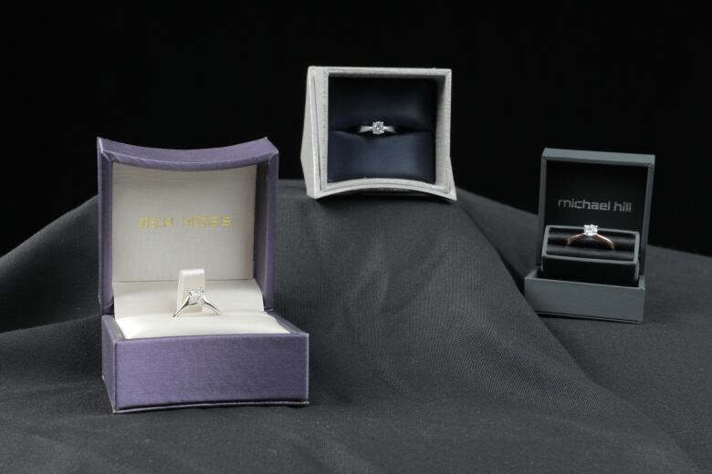 Three diamond rings in three boxes. One from Ben Moss, one from Peoples Jewellers, and one from Michael Hill.