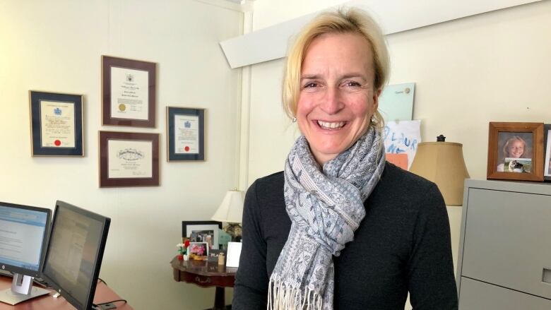 Woman wearing a scarf and dress in a medical office.  