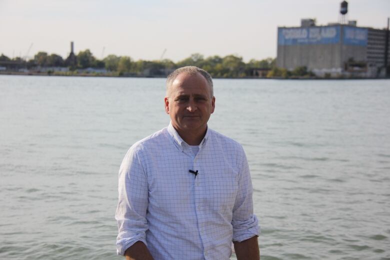 Chris Houser, a University of Windsor professor, stands by water. 