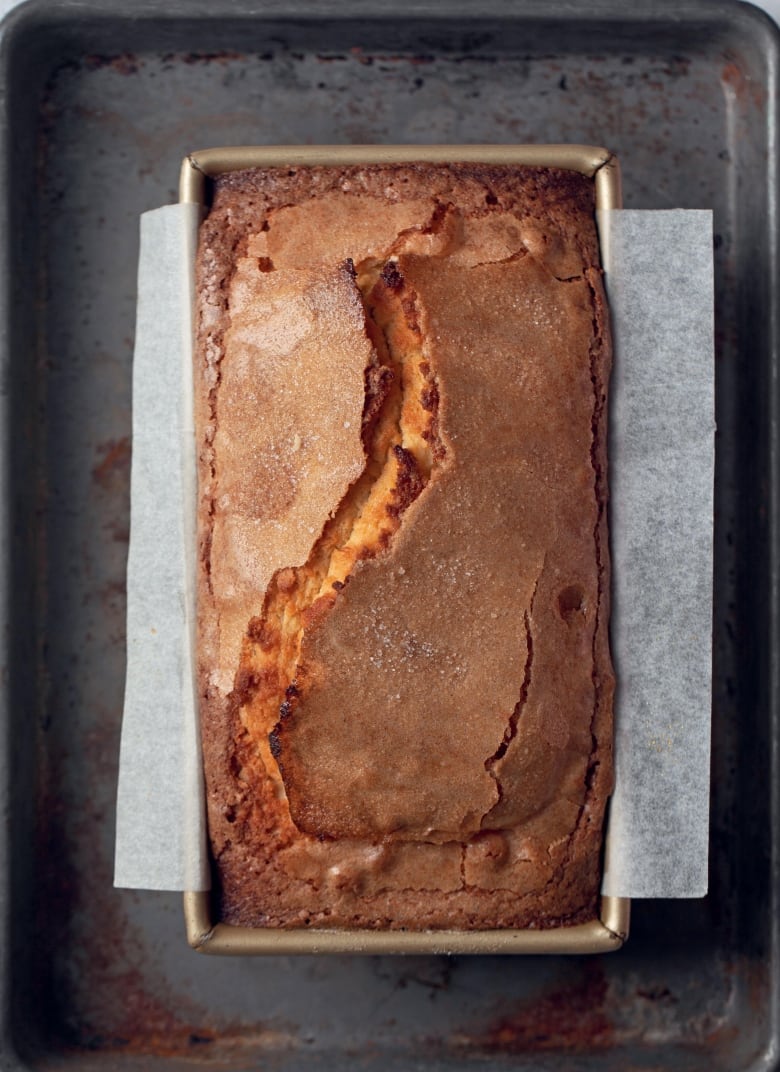 an overhead shot of a pound cake in a loaf pan on top of a baking sheet