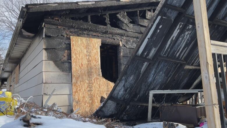 Charred remnants of a still standing house.