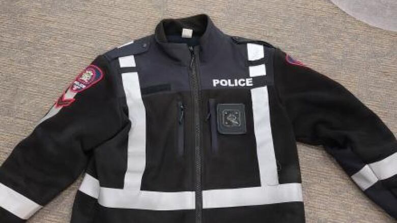 a black jacket with the word police emblazoned at the front 